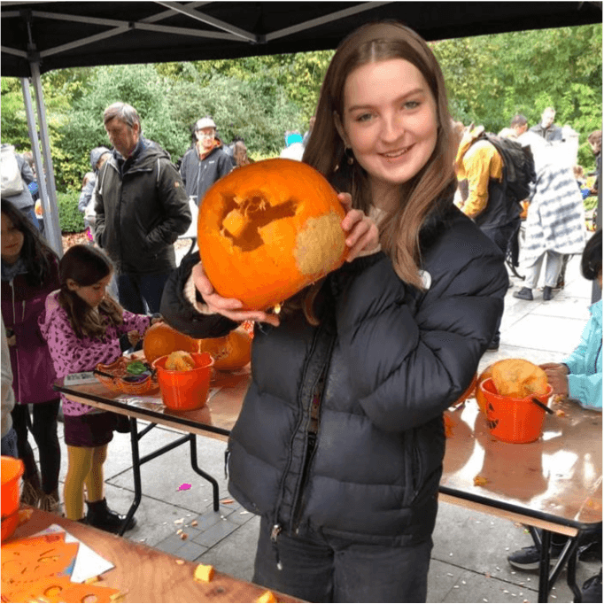 Young girl showing off her carved pumpkin